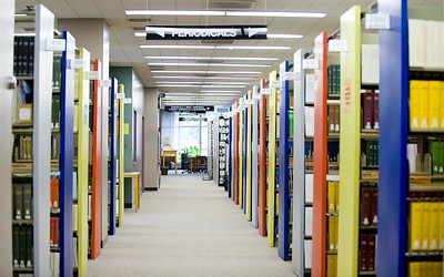 aisle between colorful book cases inside of the library