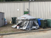 Existing conditions of the Earth Tub: covered by a gray tarp and weighed down by bricks and some other objects